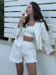 Woman in a white outfit eating ice cream against a white background