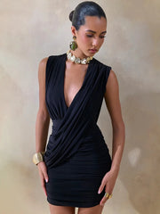 Woman wearing a black dress with a deep neckline against a neutral background