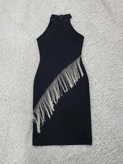 Black dress with fringe details on a light gray surface