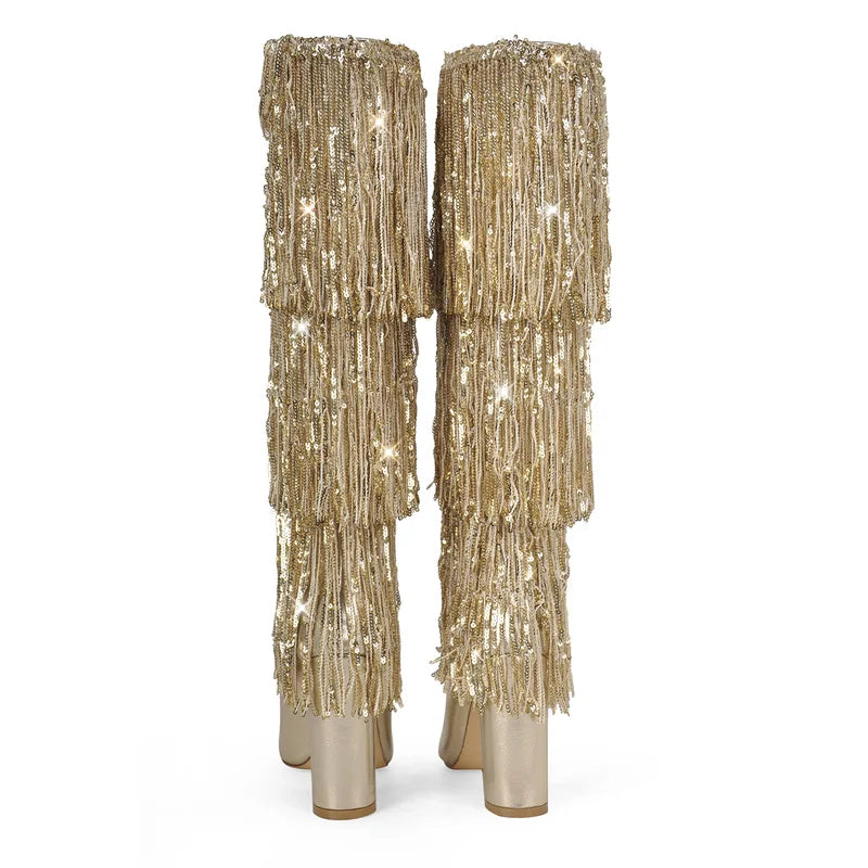 Rear view of gold pointed toe knee high boots with layered fringe