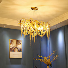 A luxurious French tassel chandelier with a golden finish illuminating a stylish living room. E