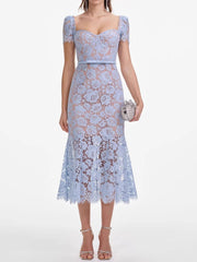 Woman wearing a light blue lace dress on a white background