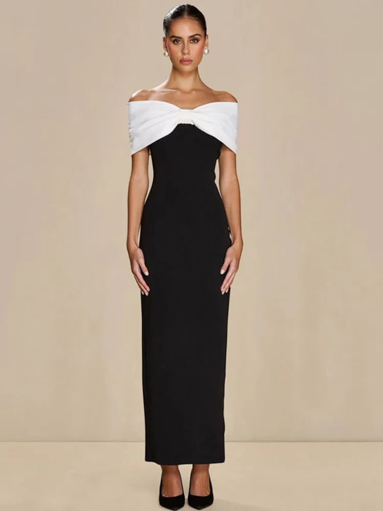 Woman wearing a black and white off-shoulder dress against a beige background