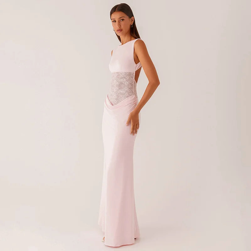Woman wearing a pink evening gown with a silver waistband on a white background