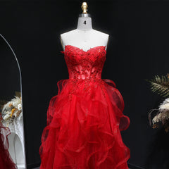 Red evening gown on a mannequin against a black background