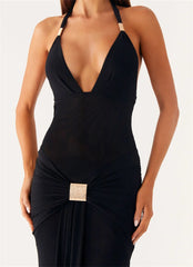 Black evening gown with a deep neckline and embellishment on a white background