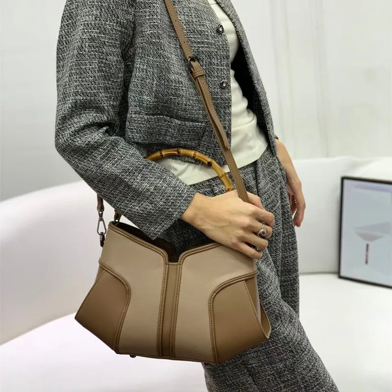 Side view of a bamboo handle colorblock leather handbag