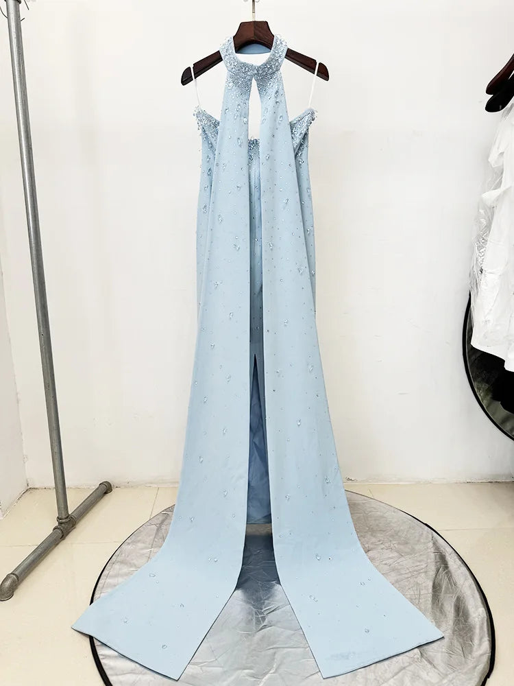 Strapless long gown with diamond embellishments and detachable cape on hanger.