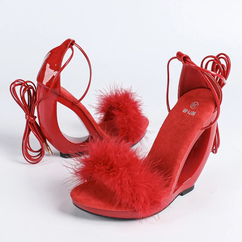 Red high-heeled shoes with feather details on a white background