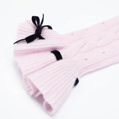 Detail of the flared cuff with black velvet bow on pink sweater