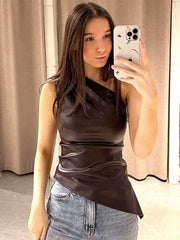 Woman taking a mirror selfie wearing a brown one-shoulder top and jeans.