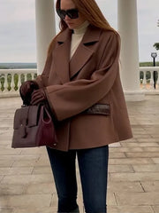 A model wearing a stylish leather patchwork wool jacket with a double-breasted closure and lapel collar.