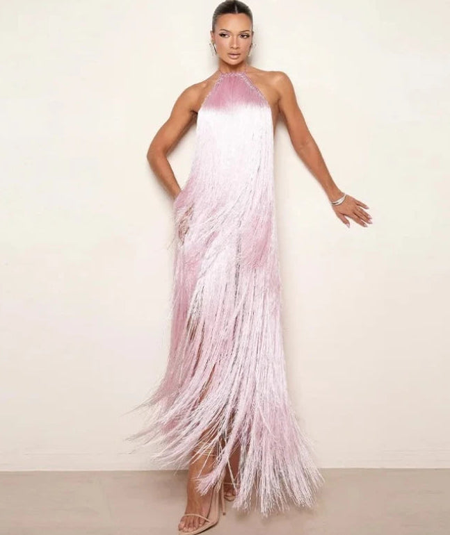 Woman wearing a pink and white fringe dress against a plain background