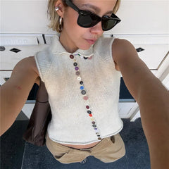 Person wearing a sleeveless button-up top with a white background