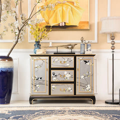 Decorative cabinet with floral designs in a room with a painting and lamp.