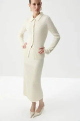 Model posing in cream ribbed knit polo top and midi skirt