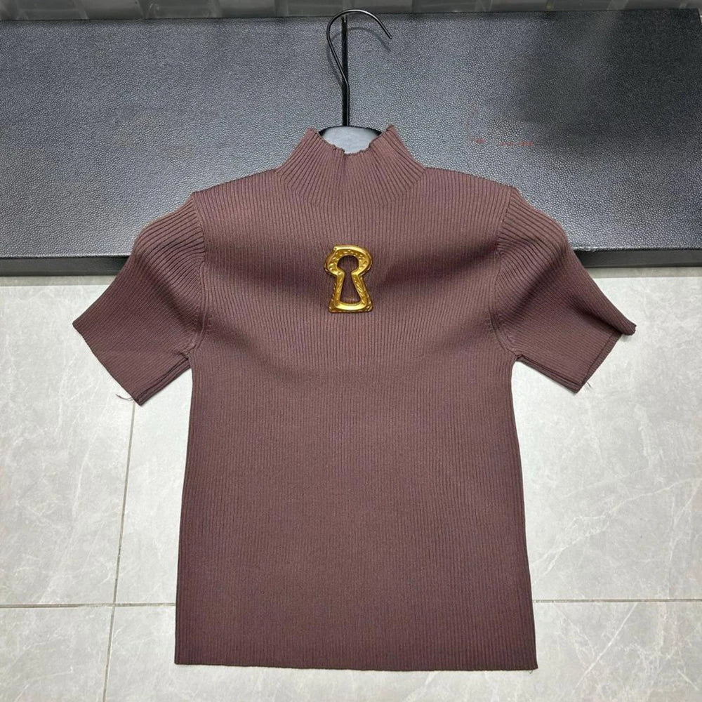 Brown ribbed sweater with a gold keyhole design on a hanger against a gray background.