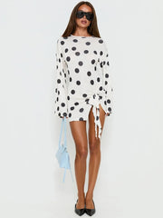 Full body shot of a polka dot ruched mini dress