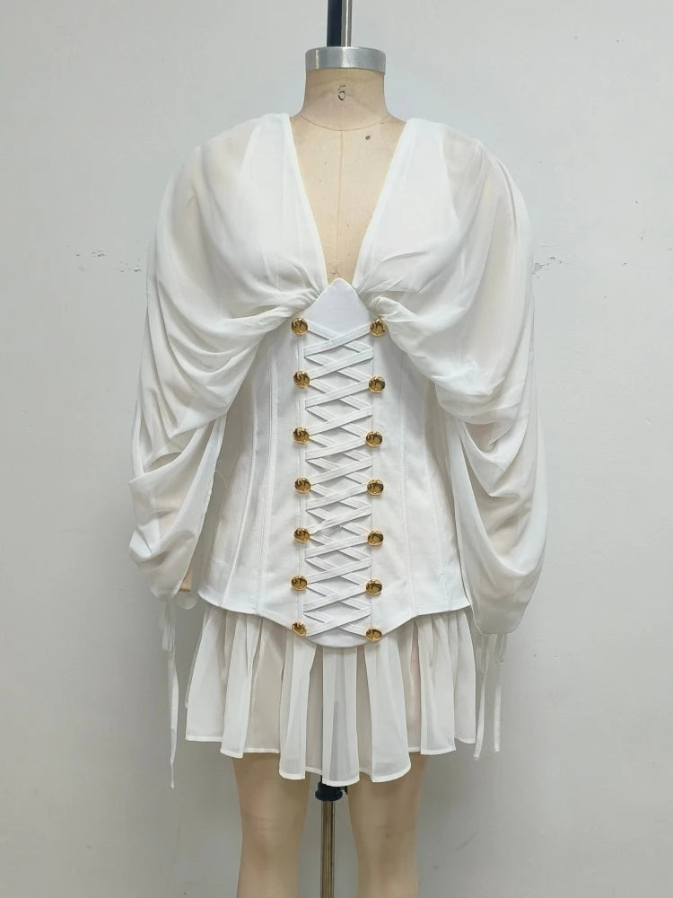 White dress with gold buttons on a mannequin against a plain background