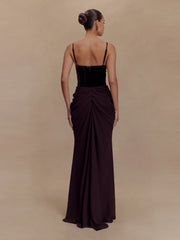 Woman wearing a black evening gown with a draped design on a beige background