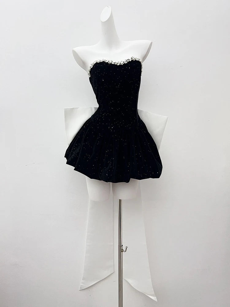 Black strapless dress on a mannequin against a white background
