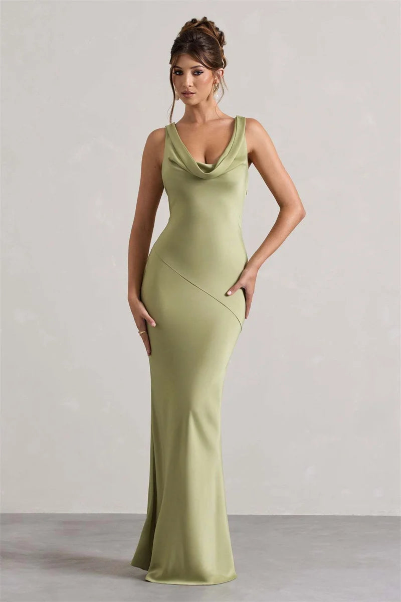 Woman wearing a green evening gown against a plain background