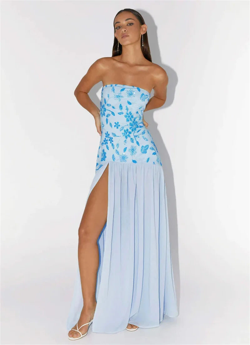 Woman wearing a strapless dress with blue floral top and light blue skirt on a white background