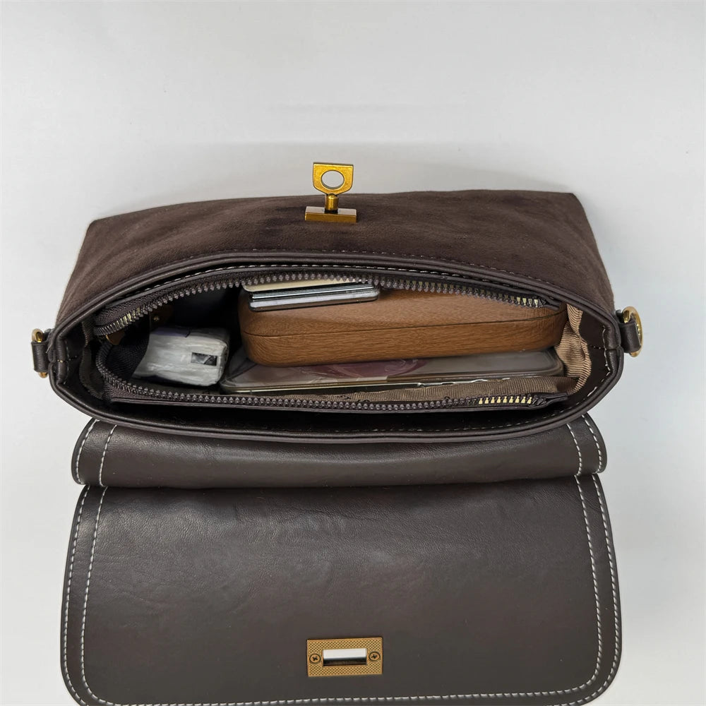 Brown leather bag with gold hardware on a white background