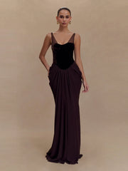 Woman wearing a dark brown evening gown against a beige background