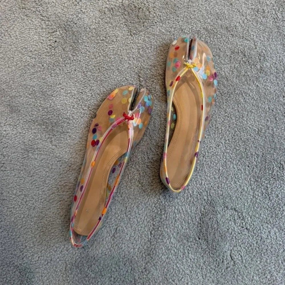 Pair of transparent split-toe flats with colorful polka dots