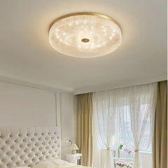 A modern round acrylic ceiling light with LED lights, illuminating a contemporary bed room.