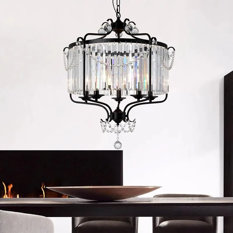 A modern crystal and iron chandelier with LED lights, illuminating a stylish dining table.