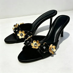 Pair of black heeled mules with floral and crystal accents