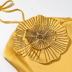 Yellow handbag with a decorative flower design on a white background