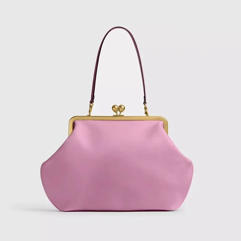 Pink handbag with a gold clasp on a light gray background