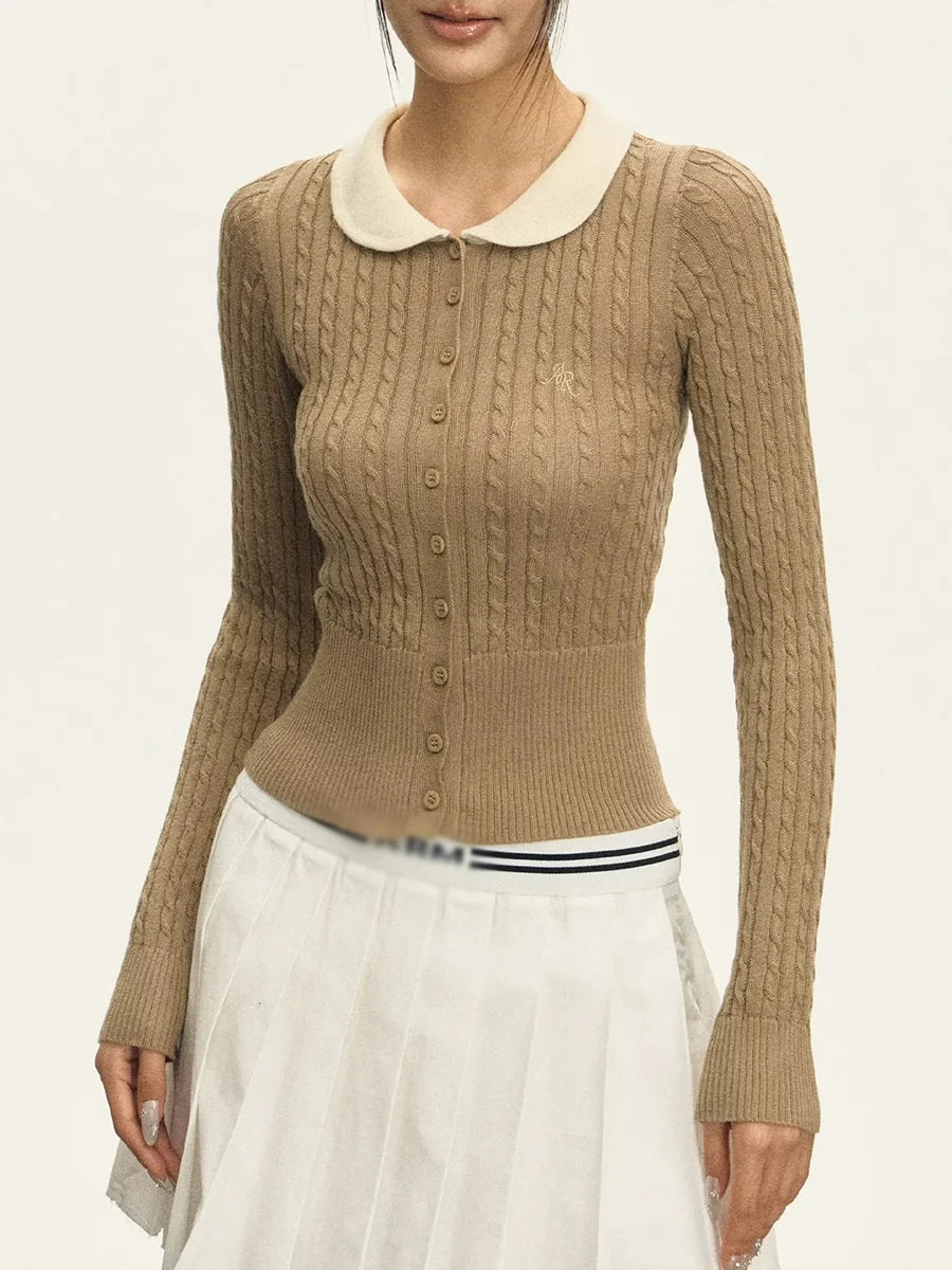 Beige cable knit sweater with a white collar worn by a person on a light gray background