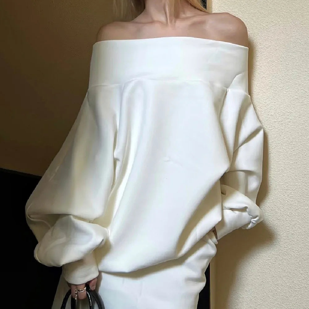 White off-shoulder top worn by a person against a neutral background