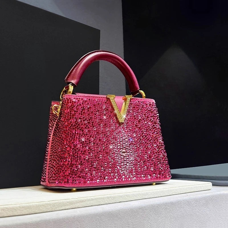 Pink crystal embellished structured bag with top handle.