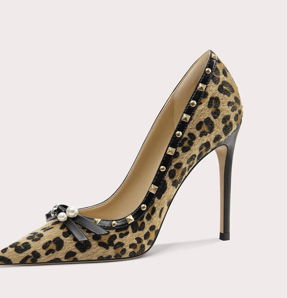 Leopard print high-heeled shoe with decorative elements on a light gray background