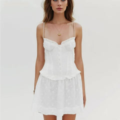 Woman wearing a white lace dress on a plain background