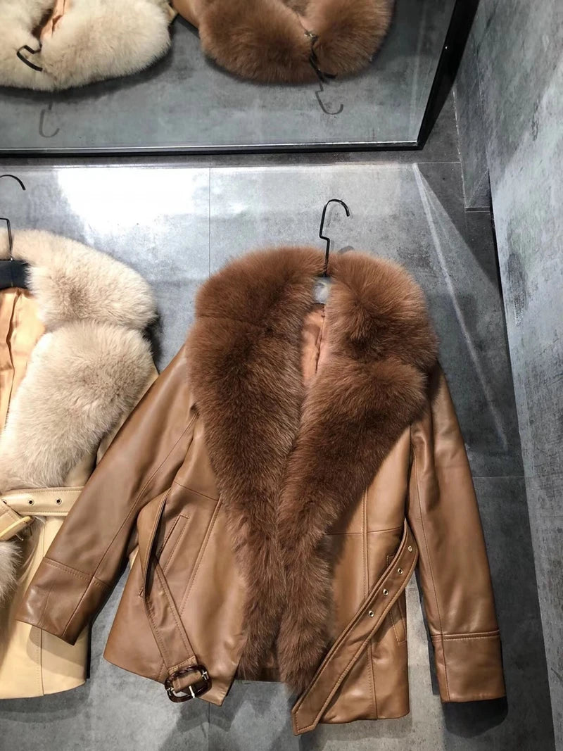 Brown leather jacket with fur collar on a hanger against a gray background