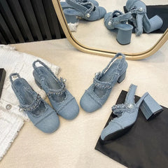 Pearl-embellished denim heels on bedroom floor setup