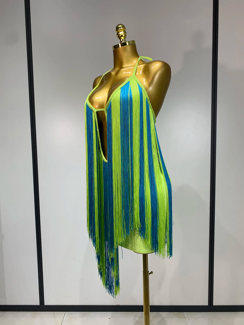 Side view of lime green and blue alternating fringe halter mini dress