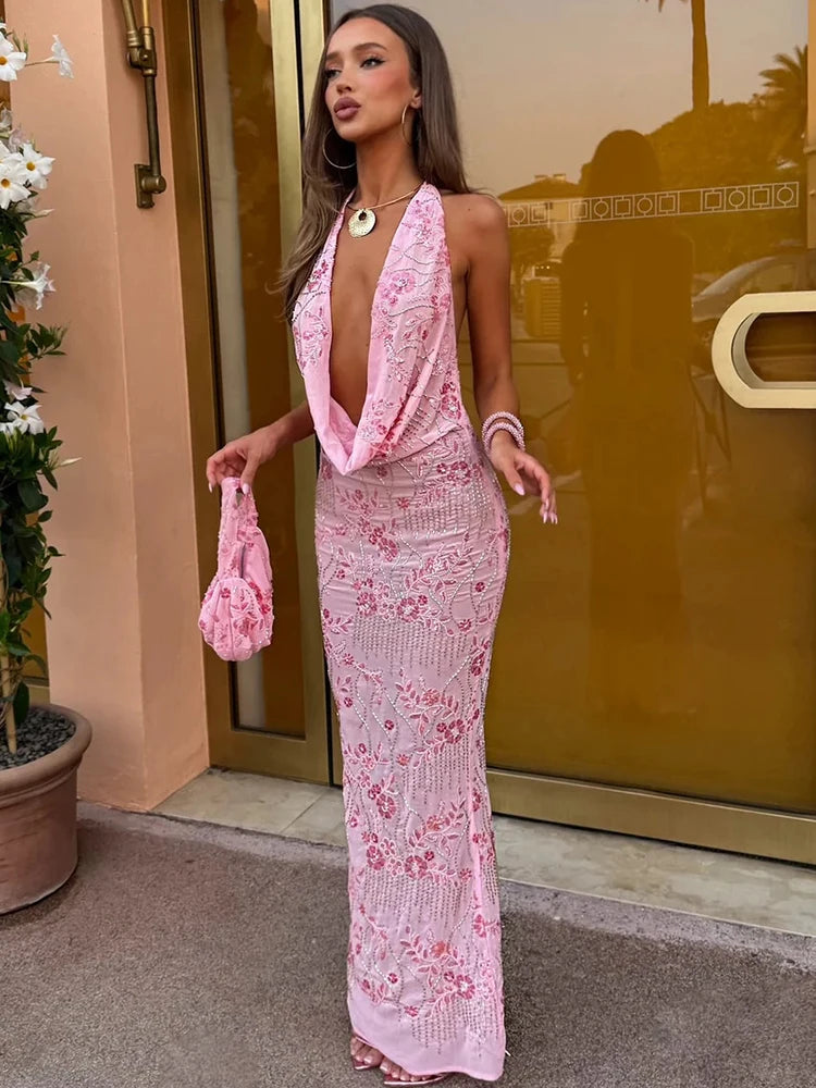 Woman in a pink lace dress standing in front of a gold door.
