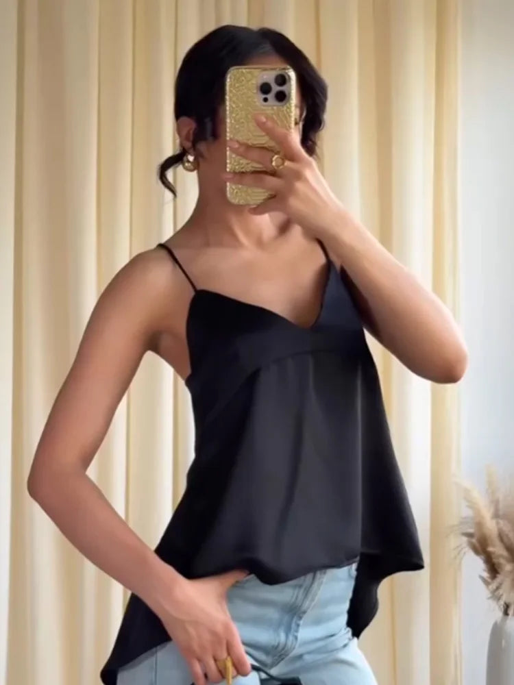 Person wearing a black top and light blue jeans, taking a mirror selfie.