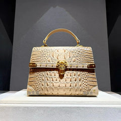 Structured crocodile embossed leather top handle bag in apricot with gold hardware.