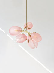 Minimalist flower bud chandelier with cream-colored accents, hanging in a modern living room. Golden Atelier 2