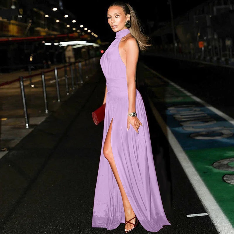 Woman in a purple evening gown standing on a track at night