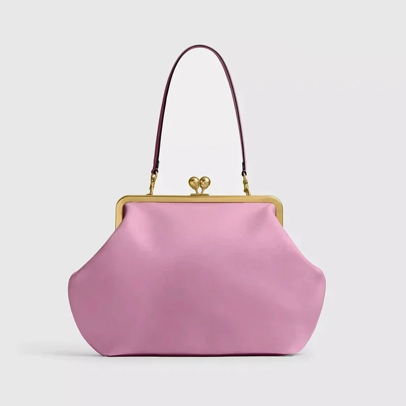 Pink handbag with a gold clasp on a light gray background