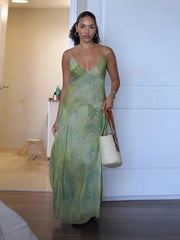 Woman in a green dress holding a straw bag indoors.